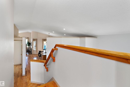 Hardwood flooring, vaulted ceiling, recessed lighting, and a wood handrail - 1046 Blackburn Close Sw, Edmonton, AB 