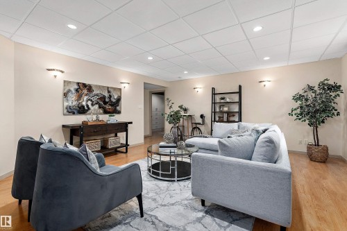 Wood-finish flooring, recessed lighting, and wall-mounted sconces - 1046 Blackburn Close Sw, Edmonton, AB 
