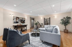 Wood-finish flooring, recessed lighting, and wall-mounted sconces - 