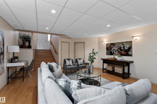 Recessed lighting, wood-finish flooring, staircase with wood risers, wall sconces, drop ceiling panels - 1046 Blackburn Close Sw, Edmonton, AB 