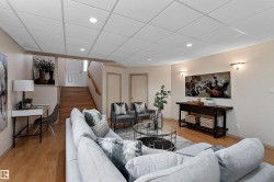 Recessed lighting, wood-finish flooring, staircase with wood risers, wall sconces, drop ceiling panels - 
