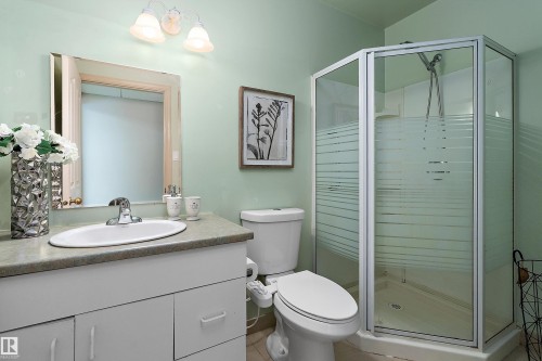 White vanity with a neutral-toned countertop and an oval undermount sink - 1046 Blackburn Close Sw, Edmonton, AB 