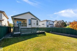 Expansive backyard featuring a manicured lawn, a multi-level wooden deck, and a privacy fence - 