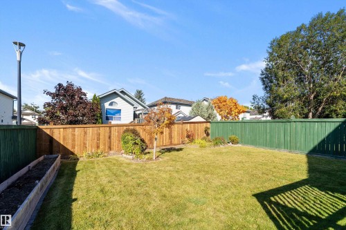 Expansive grass yard with wood fencing and a raised garden bed - 1046 Blackburn Close Sw, Edmonton, AB 