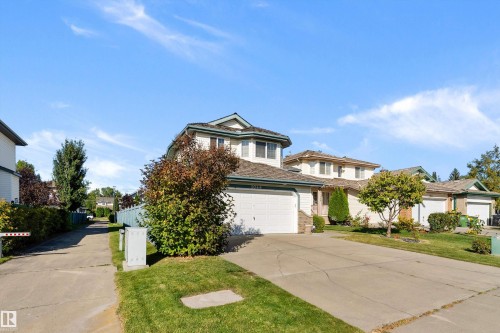 Two-story residence with attached garage, concrete driveway, and front lawn - 1046 Blackburn Close Sw, Edmonton, AB 
