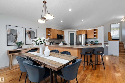 Open-concept dining and kitchen area with wood-finish flooring - 1046 Blackburn Close Sw, Edmonton, AB 
