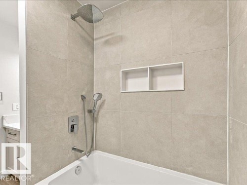 Wall-mounted shower head, integrated shower niche, handheld shower fixture, and a built-in bathtub - 18325 66 Avenue Nw, Edmonton, AB 