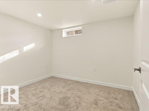 Recessed lighting, neutral wall paint, light-colored carpeting, and a small transom window - 18325 66 Avenue Nw, Edmonton, AB 