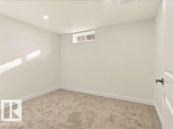 Recessed lighting, neutral wall paint, light-colored carpeting, and a small transom window - 