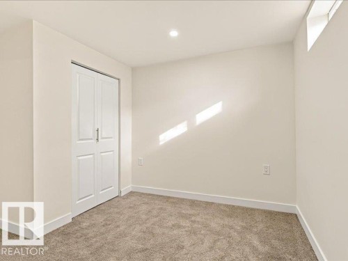 Neutral-toned wall paint with recessed ceiling lighting, carpeted flooring, and a white bi-fold closet door - 18325 66 Avenue Nw, Edmonton, AB 