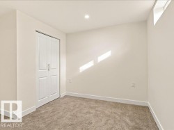 Neutral-toned wall paint with recessed ceiling lighting, carpeted flooring, and a white bi-fold closet door - 