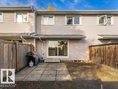 Private fenced backyard with a patio area and sliding glass door access - 18325 66 Avenue Nw, Edmonton, AB 
