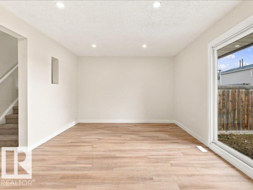 Recessed lighting, wood-finish flooring, white walls, sliding glass door, and a built-in wall niche - 18325 66 Avenue Nw, Edmonton, AB 