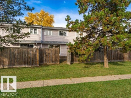 Siding exterior with multiple windows and a wood fence - 18325 66 Avenue Nw, Edmonton, AB 