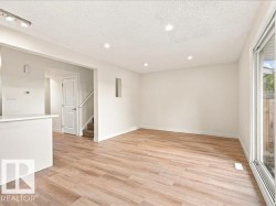 Recessed lighting, wood-finish flooring, white walls, and a sliding glass door - 