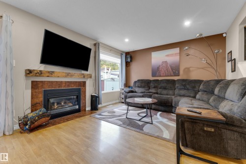 Integrated gas fireplace with a wood mantel and tile surround - 1920 145 Avenue Nw, Edmonton, AB 
