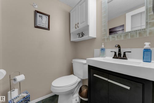 Vanity with integrated sink, dark wood-finish cabinetry, and oil-rubbed bronze faucet - 1920 145 Avenue Nw, Edmonton, AB 