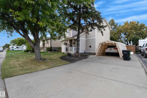 Two-story exterior with siding, a covered front porch, and a paved driveway - 1920 145 Avenue Nw, Edmonton, AB 
