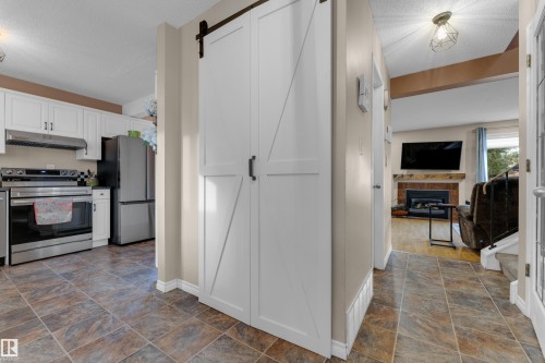 Tile flooring throughout the hallway and kitchen - 1920 145 Avenue Nw, Edmonton, AB 