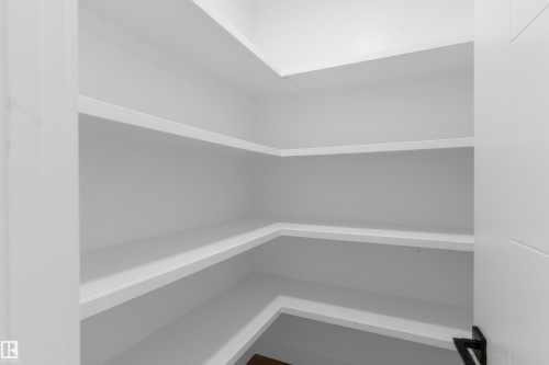 Built-in shelving with multiple levels, white finish, and corner configuration - 512 Robinson Boulevard, Leduc, AB 