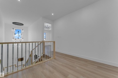 Wood-finish flooring, recessed lighting, and a contemporary chandelier - 512 Robinson Boulevard, Leduc, AB 