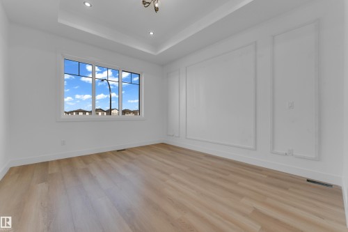 Recessed lighting, tray ceiling, large window, wood-finish flooring, and decorative wall molding - 512 Robinson Boulevard, Leduc, AB 