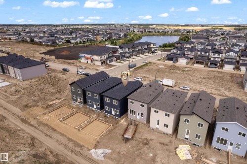 Newly constructed properties featuring dark shingled roofs and light-toned siding - 512 Robinson Boulevard, Leduc, AB 