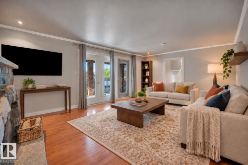 Hardwood floors, large patio doors and stone fireplace. Wall mounted TV (included). Virtually staged for inspiration. - 895 Lee Ridge Road Nw, Edmonton, AB 