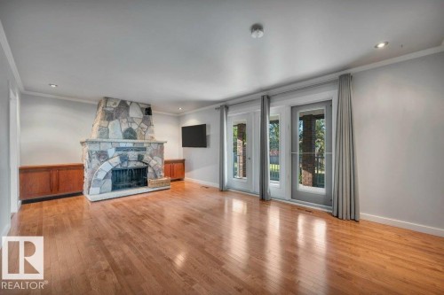 With beautiful wood-burning, stone faced fireplace and built in cabinetry - 895 Lee Ridge Road Nw, Edmonton, AB 