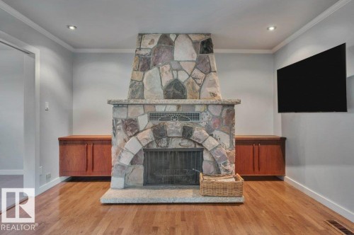 Stone-faced, wood-burning fireplace with built in cabinetry. TV and wall mount (swivels) included. - 895 Lee Ridge Road Nw, Edmonton, AB 