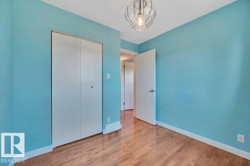 Bedroom 2 looking towards closet and hallway. Hardwood floors. - 895 Lee Ridge Road Nw, Edmonton, AB 