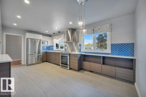With two-tone cabinets, decorative backsplash tile, tile floors, and premium stainless steel appliances - 895 Lee Ridge Road Nw, Edmonton, AB 