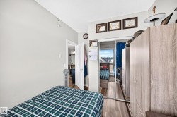 Wood-finish flooring with a mirrored closet, and a white interior door - 