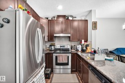 Stainless steel appliances, wood-finish cabinetry, built-in dishwasher, and a double-basin sink - 