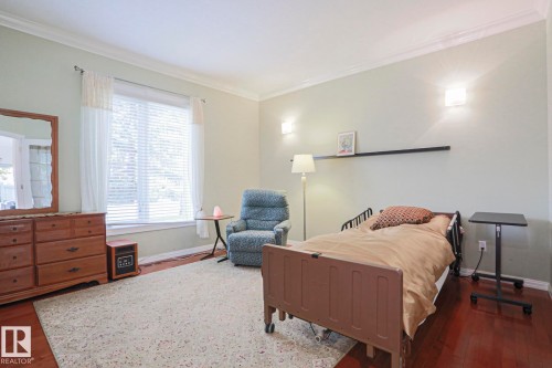 Hardwood flooring, crown molding, large window with blinds, wall sconce lighting, and a floating wall shelf - 995 Ogilvie Boulevard Nw, Edmonton, AB 