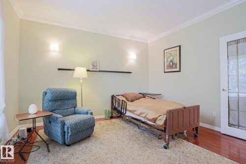 Hardwood-style flooring with crown molding and wall sconces - 995 Ogilvie Boulevard Nw, Edmonton, AB 