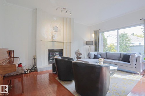 Hardwood flooring, recessed fireplace, track lighting, crown molding, and large window - 995 Ogilvie Boulevard Nw, Edmonton, AB 