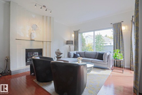 Hardwood flooring, crown molding, track lighting, built-in fireplace, and expansive windows - 995 Ogilvie Boulevard Nw, Edmonton, AB 