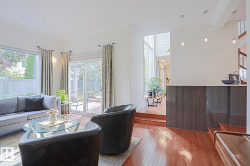 Hardwood flooring, sliding glass door access to an exterior patio, two large windows, recessed wall lighting, and pendant lighting fixtures - 995 Ogilvie Boulevard Nw, Edmonton, AB 