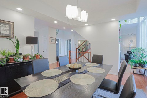 Dining area featuring recessed lighting, a contemporary chandelier, and hardwood flooring - 995 Ogilvie Boulevard Nw, Edmonton, AB 