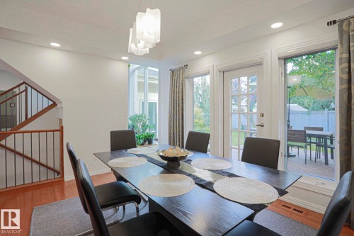 Recessed lighting, contemporary chandelier, hardwood-finish flooring, staircase with wood handrail and metal spindles, glass-paneled patio door - 995 Ogilvie Boulevard Nw, Edmonton, AB 