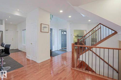 Hardwood-finish flooring throughout, recessed lighting, wood staircase with metal balusters, and a contemporary color palette - 995 Ogilvie Boulevard Nw, Edmonton, AB 