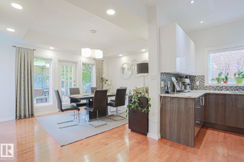 Hardwood flooring, recessed lighting, and a modern chandelier illuminate the dining space - 995 Ogilvie Boulevard Nw, Edmonton, AB 