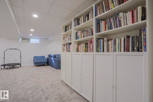 Built-in shelving with lower storage cabinetry, recessed lighting, drop ceiling, and carpeted flooring - 995 Ogilvie Boulevard Nw, Edmonton, AB 