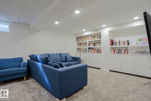 Expansive built-in shelving with lower cabinetry, recessed lighting, and soft carpet flooring - 995 Ogilvie Boulevard Nw, Edmonton, AB 
