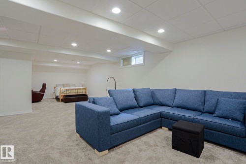 Recessed lighting, light-colored walls, carpet flooring, and an egress window - 995 Ogilvie Boulevard Nw, Edmonton, AB 
