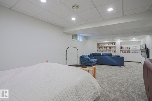 Recessed lighting illuminates the carpeted flooring and built-in shelving - 995 Ogilvie Boulevard Nw, Edmonton, AB 