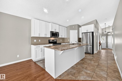 White cabinetry with stainless steel hardware, granite countertops, stainless steel appliances, and recessed lighting - 21 Silverstone Drive, Stony Plain, AB 