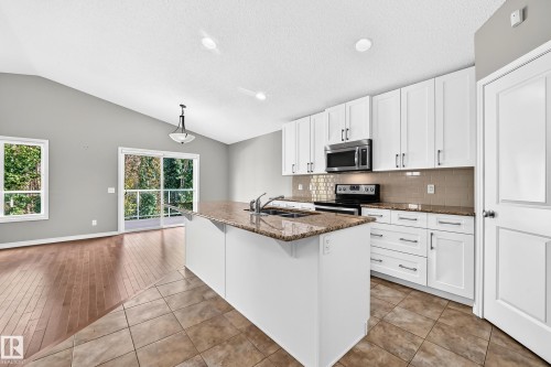 White cabinetry, stainless steel appliances, and a kitchen island with a double sink - 21 Silverstone Drive, Stony Plain, AB 