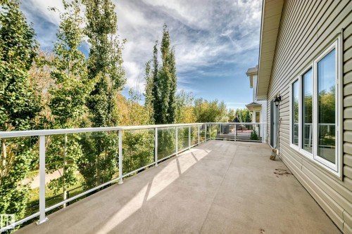 Expansive concrete deck featuring a glass and aluminum railing - 21 Silverstone Drive, Stony Plain, AB 